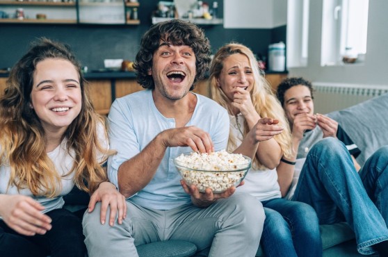 Una família mirant una pel·lícula al sofà.